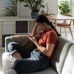 functional freeze state vs how to stop being lazy, woman on couch on phone